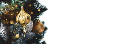 Golden toy on Christmas tree with tinsel garland on white background. Holiday banner with copy space. Wide panoramic headerの写真素材