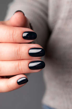 Female hand with beautiful manicure - dark black nails. Nail care conceptの写真素材