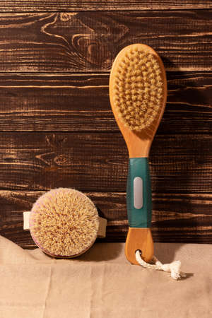 Dry massage brushes from natural materials for body care on linen and wooden background