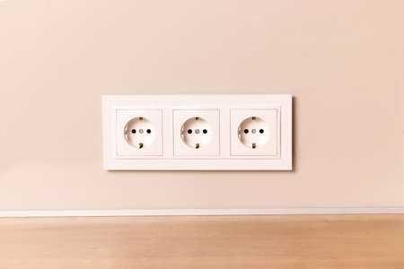 Group of white european electrical outlets on modern neutral beige wallの写真素材