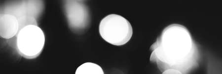 Blurred lights black and white background, banner texture. Abstract bokeh with soft light header. Wide screen wallpaper. Panoramic web banner with copy space for designの写真素材