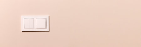 Group of white electrical switches on modern beige wall with copy space banner. Wide panoramic...