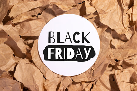 Black Friday sign on white circle on multiple pieces of torn brown crumpled, wrinkled recycle craft paper background. Shopping conceptの写真素材