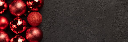 Christmas banner with red bauble balls decorations on black background with copy space. Wide panoramic headerの写真素材