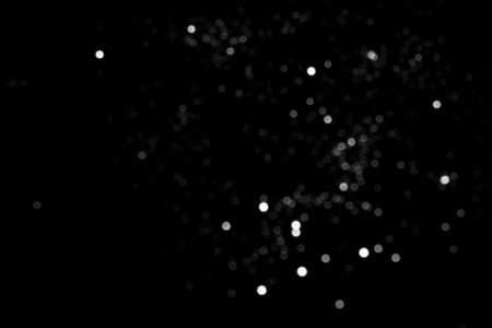 White gray blurred bokeh lights on black background. Glitter sparkle stars for celebrate. Overlay for your designの写真素材