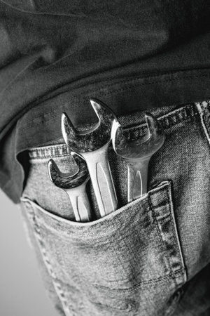 Man with wrenches in back pocket of his jeans. Ideal for industrial, mechanical, and DIY projects. Black and white photoの写真素材