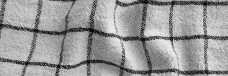 Classic black and white checkered kitchen towel texture banner. Crumpled fabric textile background with visible weave and thread detail. Top view panoramic web header. Wide screen wallpaperの写真素材
