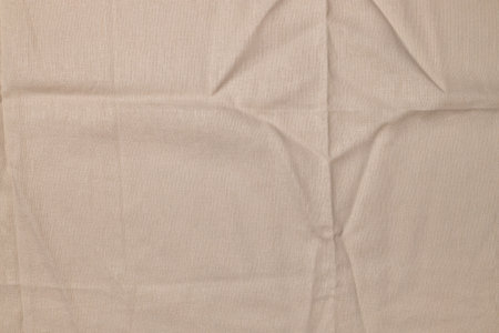 Closeup of rough, crumpled burlap texture made of flaxen textile material. Vintage grunge background with soft beige tonesの写真素材