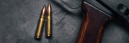 Two bullets for assault rifle on gray concrete and gradient black background banner. Cartridge 7.62...