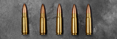 Bullets for assault rifle on gray concrete and gradient black background banner. Cartridge 7.62 caliber for ak 47 panoramic web header. Wide screen wallpaperの写真素材