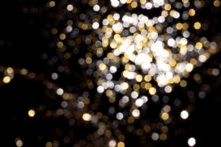 Golden and silver blurred bokeh lights on black background. Glitter sparkle stars for celebrate....