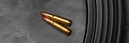 Two bullets for assault rifle on gray concrete and gradient black background banner. Cartridge 7.62 caliber for ak 47 panoramic web header. Wide screen wallpaperの写真素材