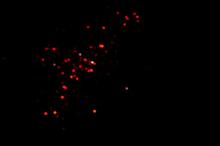 Red blurred bokeh lights on black background. Glitter sparkle confetti for celebrate. Overlay for your designの写真素材