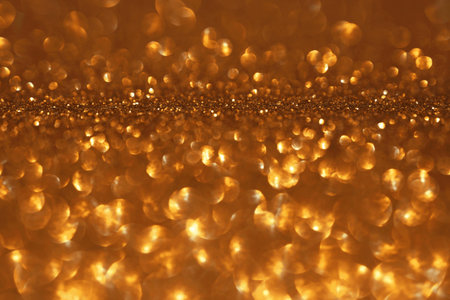 Golden glitter festive bokeh background, abstract defocused texture. Holiday lights.の写真素材