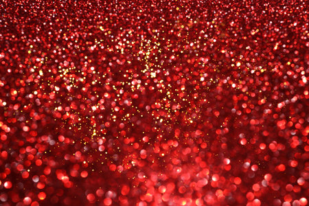 Red glitter bokeh background with sparkling light, abstract defocused texture. Holiday lights.の写真素材