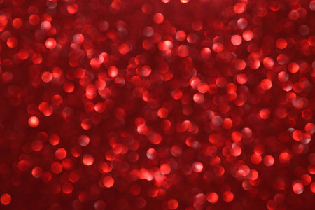 Red glitter bokeh background with sparkling light, abstract defocused texture. Holiday lights.の写真素材