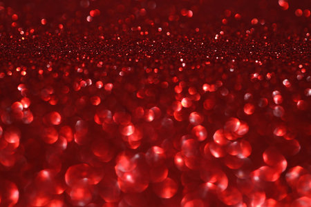 Red glitter bokeh background with sparkling light, abstract defocused texture. Holiday lights.の写真素材
