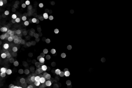 White gray blurred bokeh lights on black background. Glitter sparkle stars for celebrate. Overlay for your designの写真素材