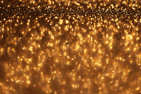 Golden glitter festive bokeh background, abstract defocused texture. Holiday lightsの写真素材
