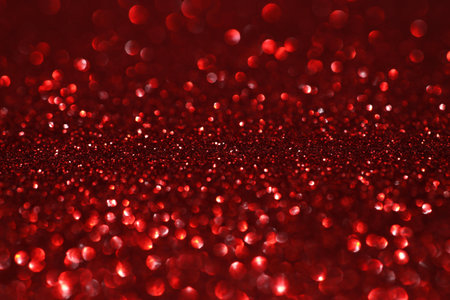 Red glitter bokeh background with sparkling light, abstract defocused texture. Holiday lights.の写真素材
