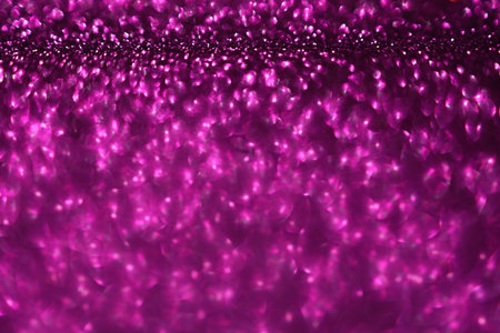 Pink magenta glitter bokeh background with defocused sparkling lights, abstract shiny texture. Holiday lights.の写真素材
