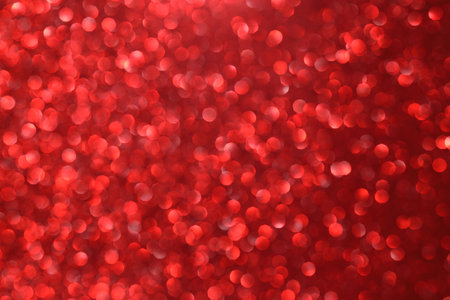 Red glitter bokeh background with sparkling light, abstract defocused texture. Holiday lights.の写真素材
