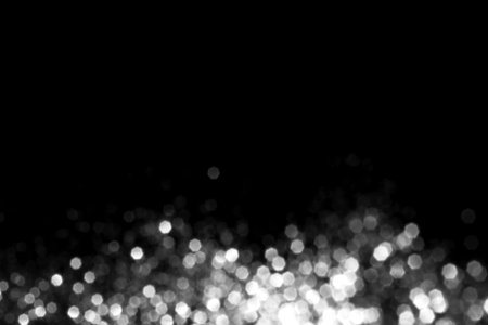 White gray blurred bokeh lights on black background. Glitter sparkle stars for celebrate. Overlay for your designの写真素材