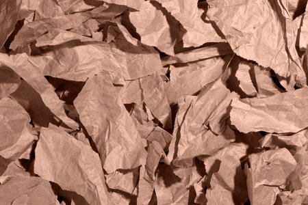 Multiple pieces of torn brown, mocha mousse crumpled, wrinkled recycle craft paper background texture, top view.の写真素材