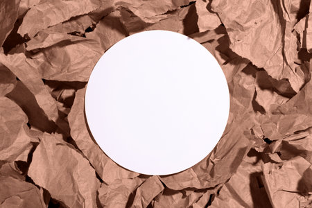 White empty blank circle mockup on multiple pieces of torn brown, mocha mousse crumpled, wrinkled recycle craft paper background. Composition with copy space and place for textの写真素材