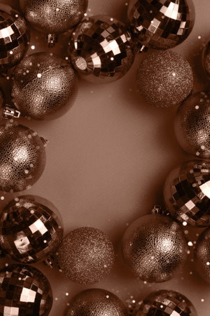 Circle frame of brown, mocha mousse Christmas bauble balls decorations on brown background with copy spaceの写真素材