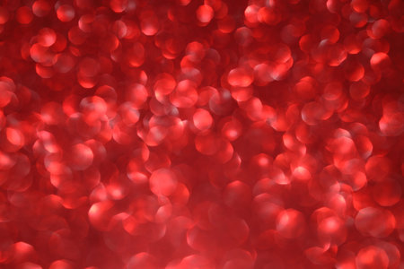Red glitter bokeh background with sparkling light, abstract defocused texture. Holiday lights.の写真素材