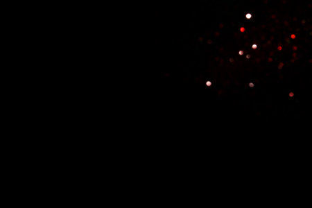 Red blurred bokeh lights on black background. Glitter sparkle confetti for celebrate. Overlay for your designの写真素材