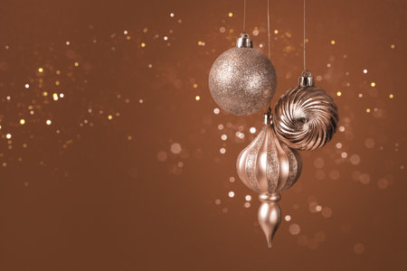 Christmas card with brown, mocha mousse ornaments on brown background with bokeh lights. Demonstrating color, trend 2025 year.の写真素材