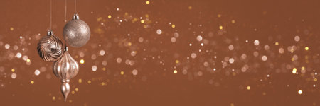 Christmas banner with three brown, mocha mousse ornaments on brown background with bokeh lights with copy space. Wide panoramic header.の写真素材