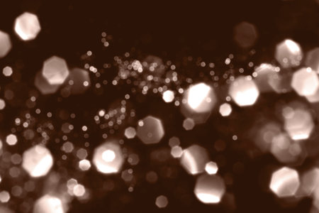 Mocha Mousse, brown blurred abstract bokeh lights on black background. Snowy shiny glitter sparkle stars for celebrate. Demonstrating color, trend 2025 year.の写真素材