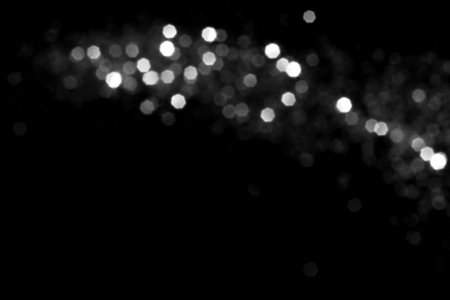 White gray blurred bokeh lights on black background. Glitter sparkle stars for celebrate. Overlay for your designの写真素材