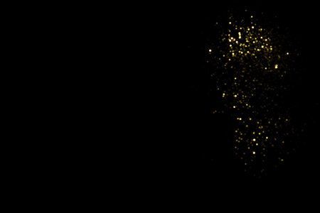 Golden blurred bokeh lights on black background. Glitter sparkle stars for celebrate. Overlay for your designの写真素材