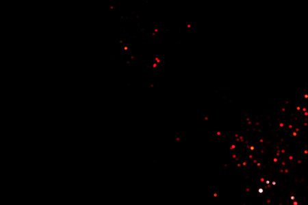 Red blurred bokeh lights on black background. Glitter sparkle confetti for celebrate. Overlay for your designの写真素材