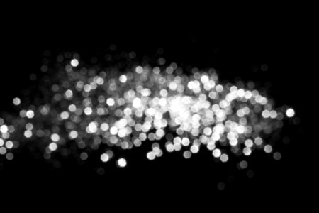 White gray blurred bokeh lights on black background. Glitter sparkle stars for celebrate. Overlay for your designの写真素材