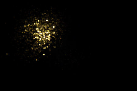 Golden blurred bokeh lights on black background. Glitter sparkle stars for celebrate. Overlay for your designの写真素材