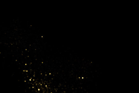 Golden blurred bokeh lights on black background. Glitter sparkle stars for celebrate. Overlay for your designの写真素材