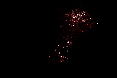 Red blurred bokeh lights on black background. Glitter sparkle confetti for celebrate. Overlay for your designの写真素材