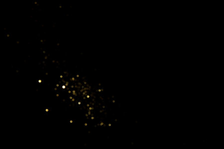 Golden blurred bokeh lights on black background. Glitter sparkle stars for celebrate. Overlay for your designの写真素材