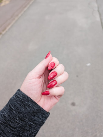 Woman hand with red nail polish, showing elegant design.の写真素材