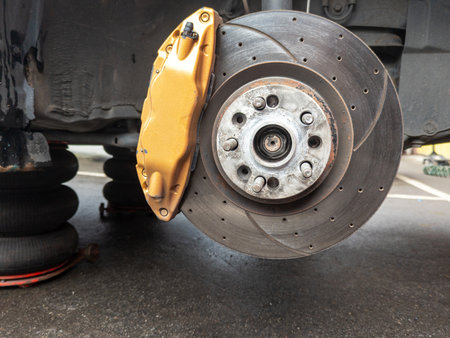 Automotive brake system featuring a yellow caliper and disc brake rotor.の写真素材