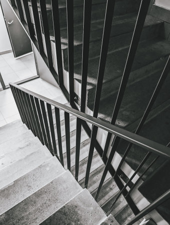 Staircase with black railings, concrete steps, modern architecture, monochrome scheme.