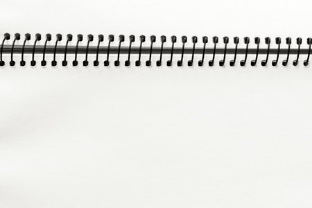 Open spiral notebook with blank empty white sheets, closeup top view, paper background. Demonstrating color, trend 2026 year.の写真素材