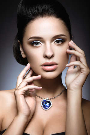 Beautiful brunette with a bright evening makeup with a necklace Heart of the Ocean.の写真素材
