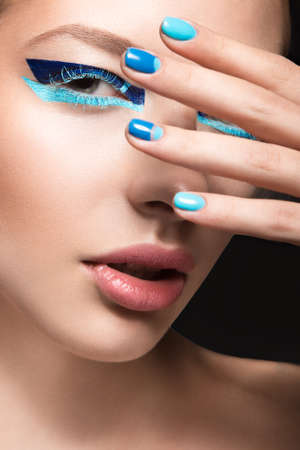 Beautiful girl with bright creative fashion makeup and blue nail polish. Art beauty nail design....