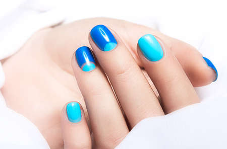 Blue manicure in light and dark colors of lacquer on a white background. Nail art designの写真素材